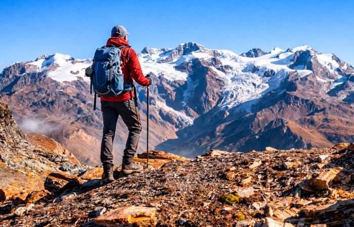 Hiker en Lares Trek frente a picos nevados andinos – Tour Lares y Machupicchu 4 días Royal Adventure Perú