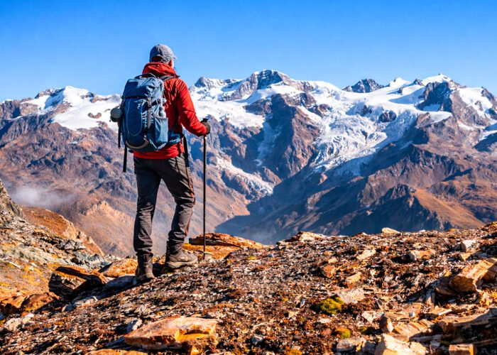 Hiker en Lares Trek frente a picos nevados andinos – Tour Lares y Machupicchu 4 días Royal Adventure Perú